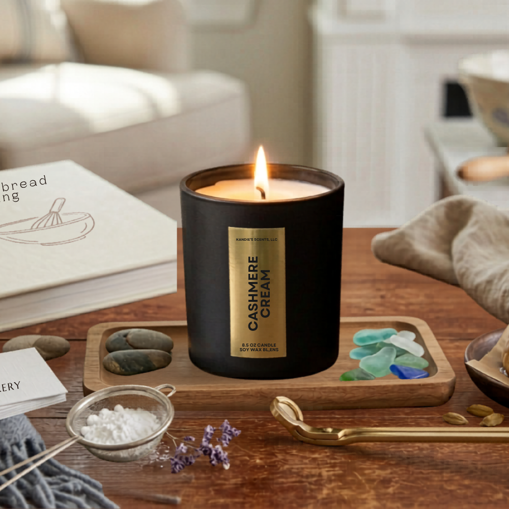 Candle labeled 'Cashmere Cream' on a wooden table with a cozy living room background