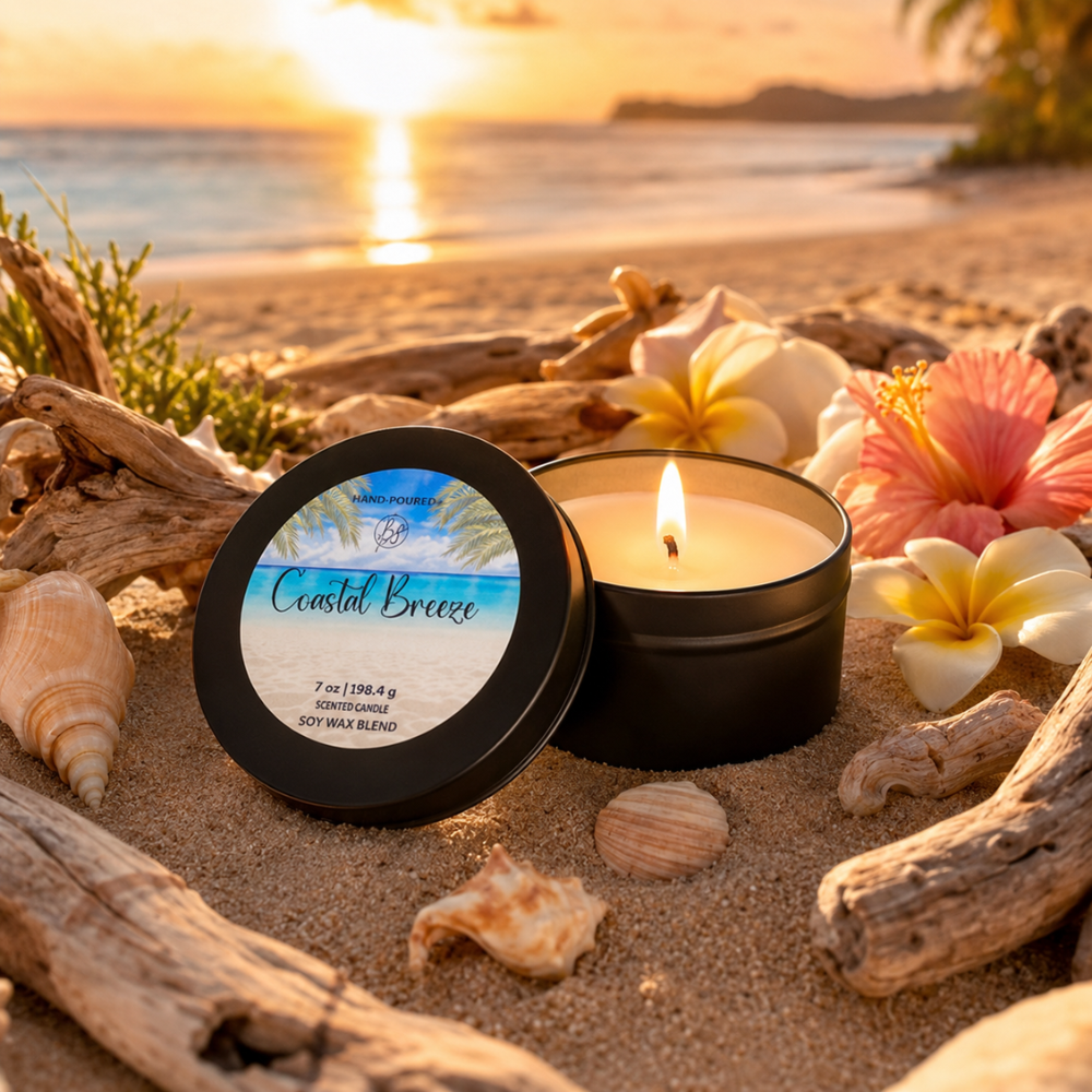 Candle labeled 'Coastal Breeze' on a beach with sunset and flowers.
