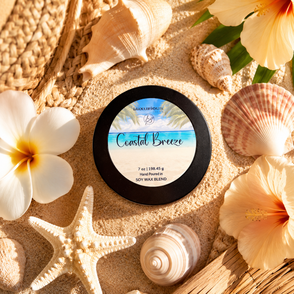 Candle tin on sand with flowers and shells