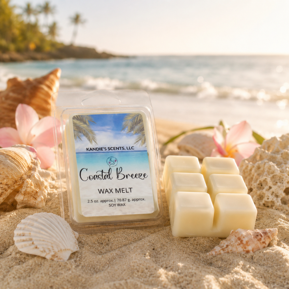 Kandie's Scents Coastal Breeze wax melt packaging on a sandy beach with shells and flowers.