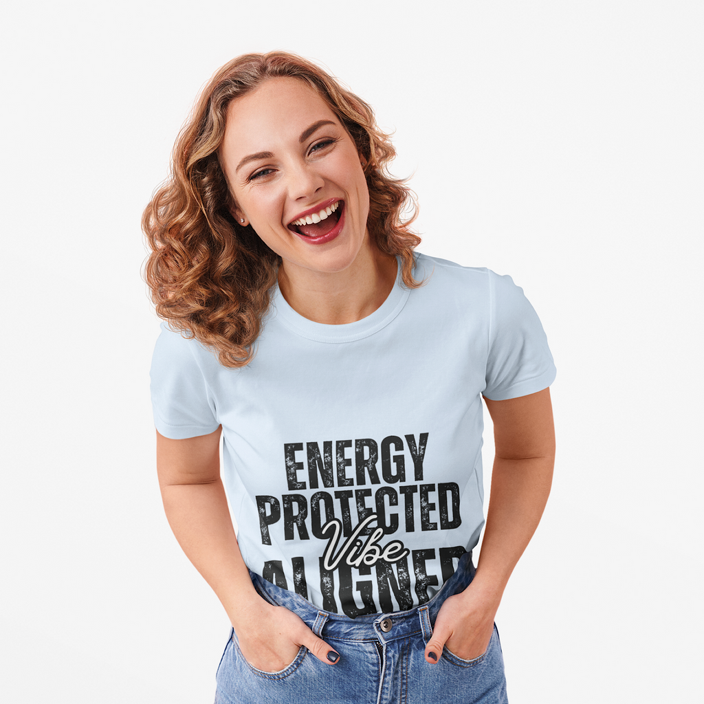 Woman wearing a light blue t-shirt with 'Energy Protected Vibe Aligned' text smiling against a white background