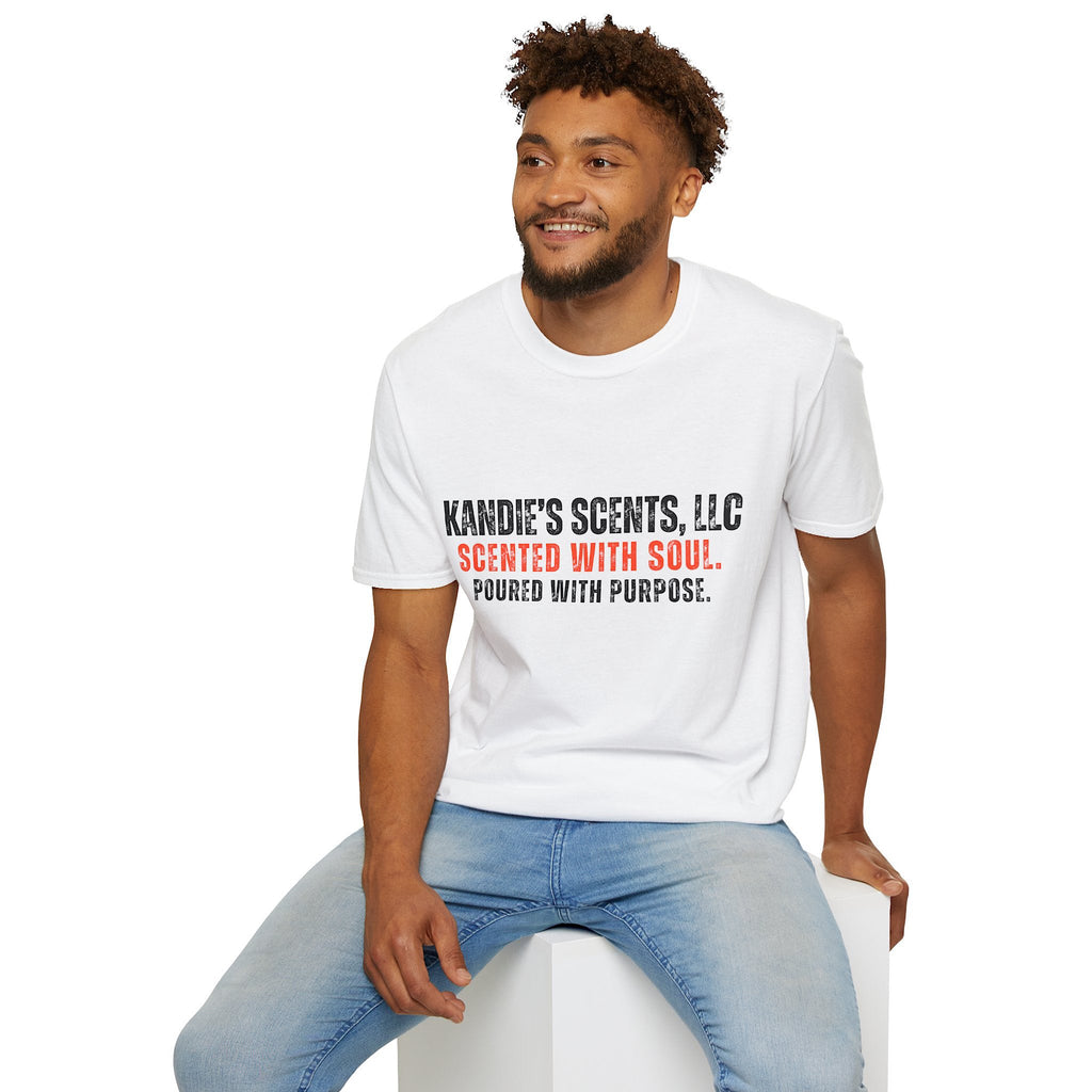 Man wearing a white t-shirt with 'Kandie's Scent, LLC- Scented with Soul. Poured with Purpose.' printed on it, sitting on a white stool against a white background.
