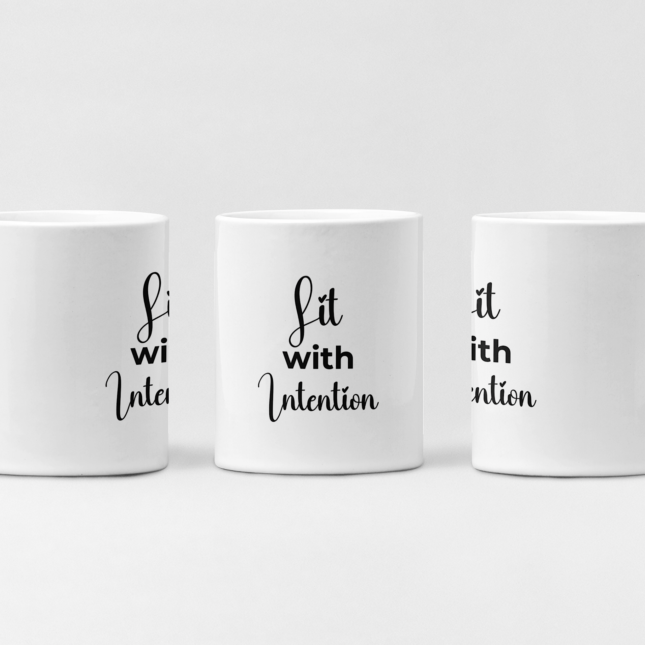 Three white mugs with black 'Lit with Intention' text on a light gray background