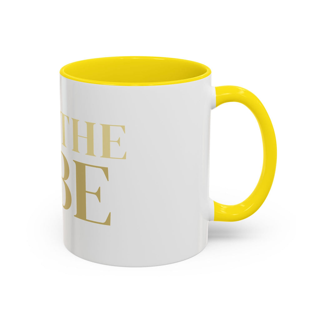 White mug with yellow interior and handle, featuring gold 'I AM THE VIBE' text on a white background