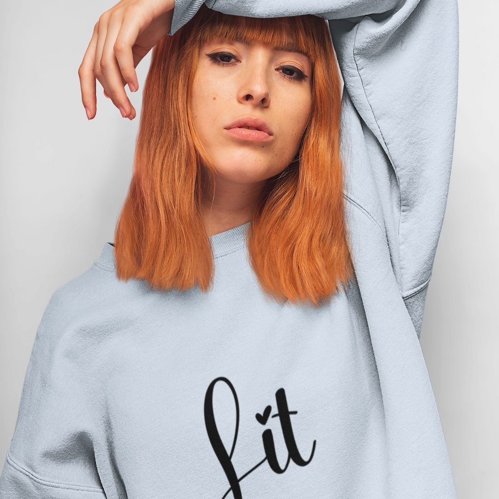 Person wearing a light gray sweatshirt with 'Lit with Intention' text on a plain background