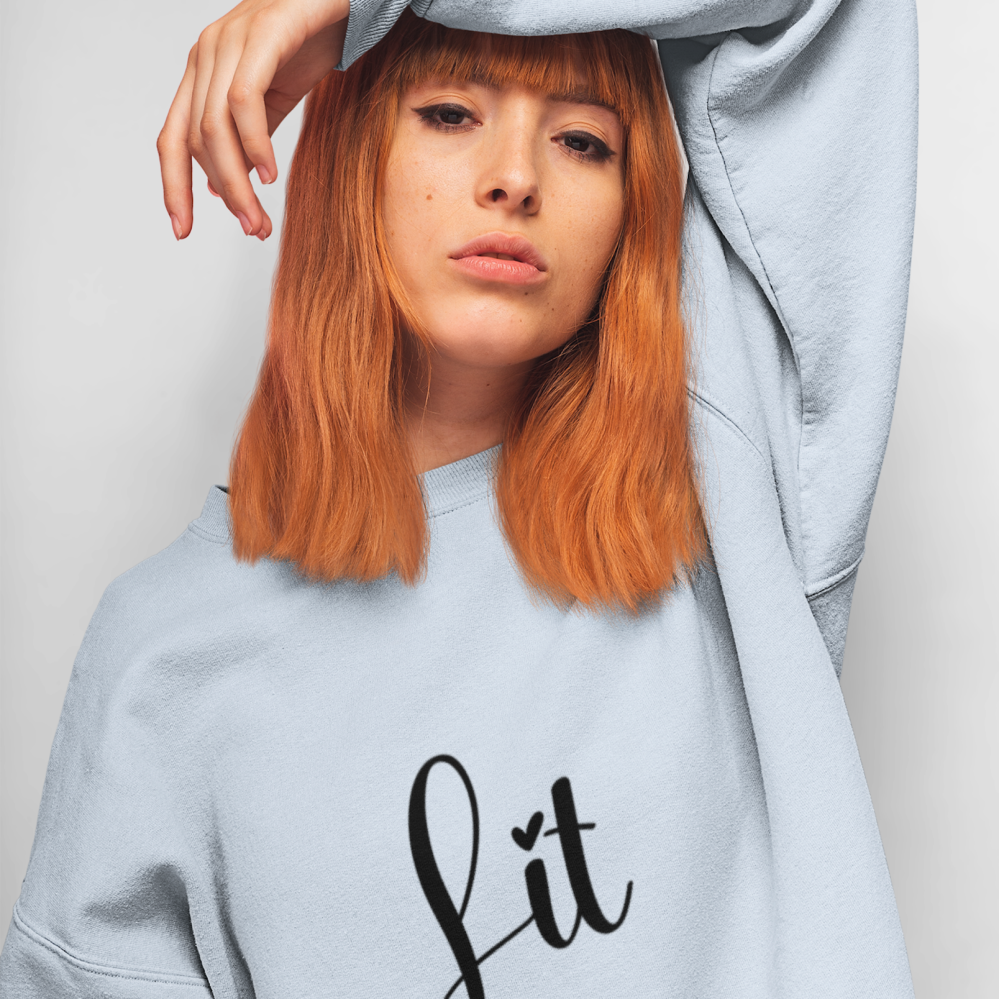 Person wearing a light gray sweatshirt with 'Lit with Intention' text on a plain background