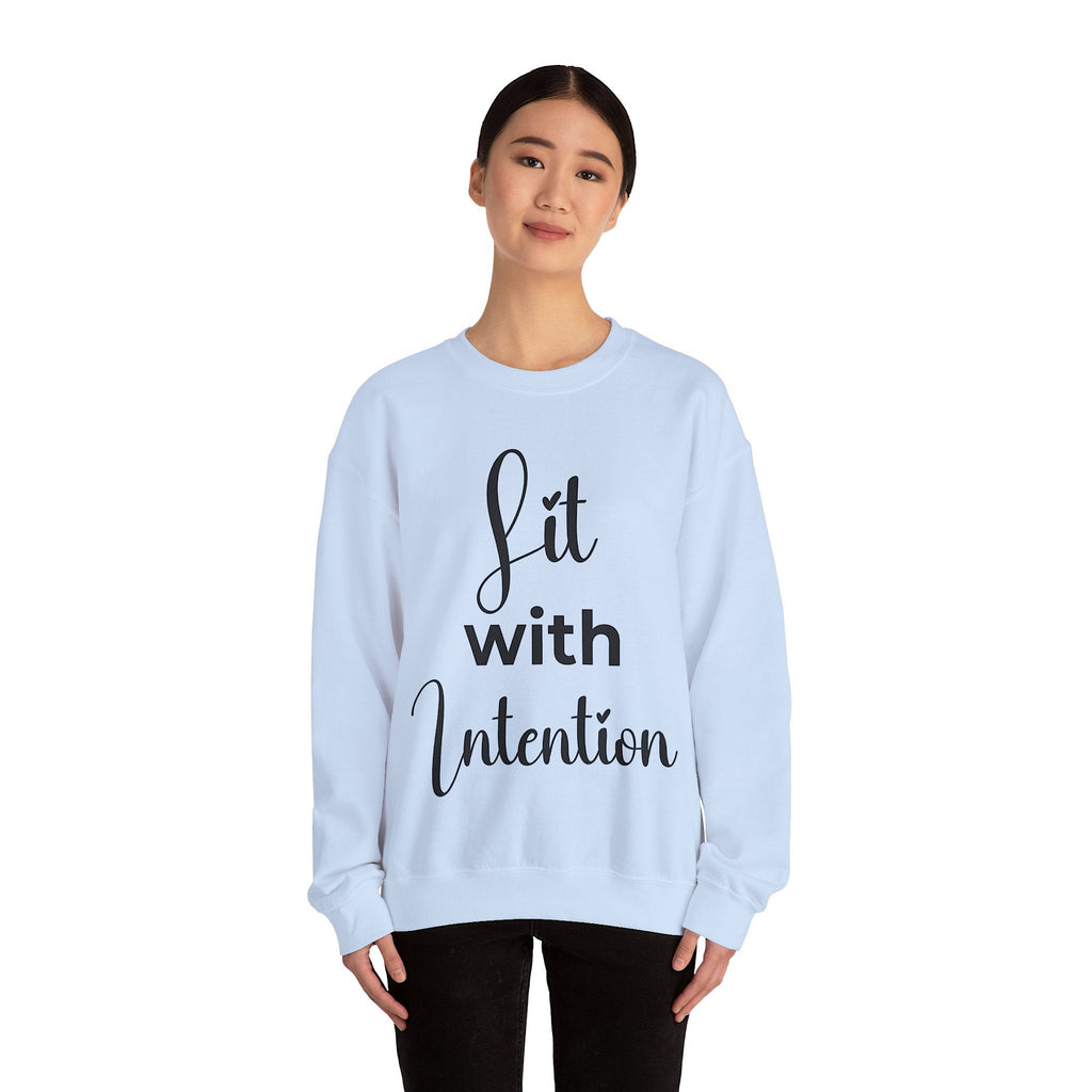 Light blue sweatshirt with 'Lit with Intention' text worn by a person on a white background