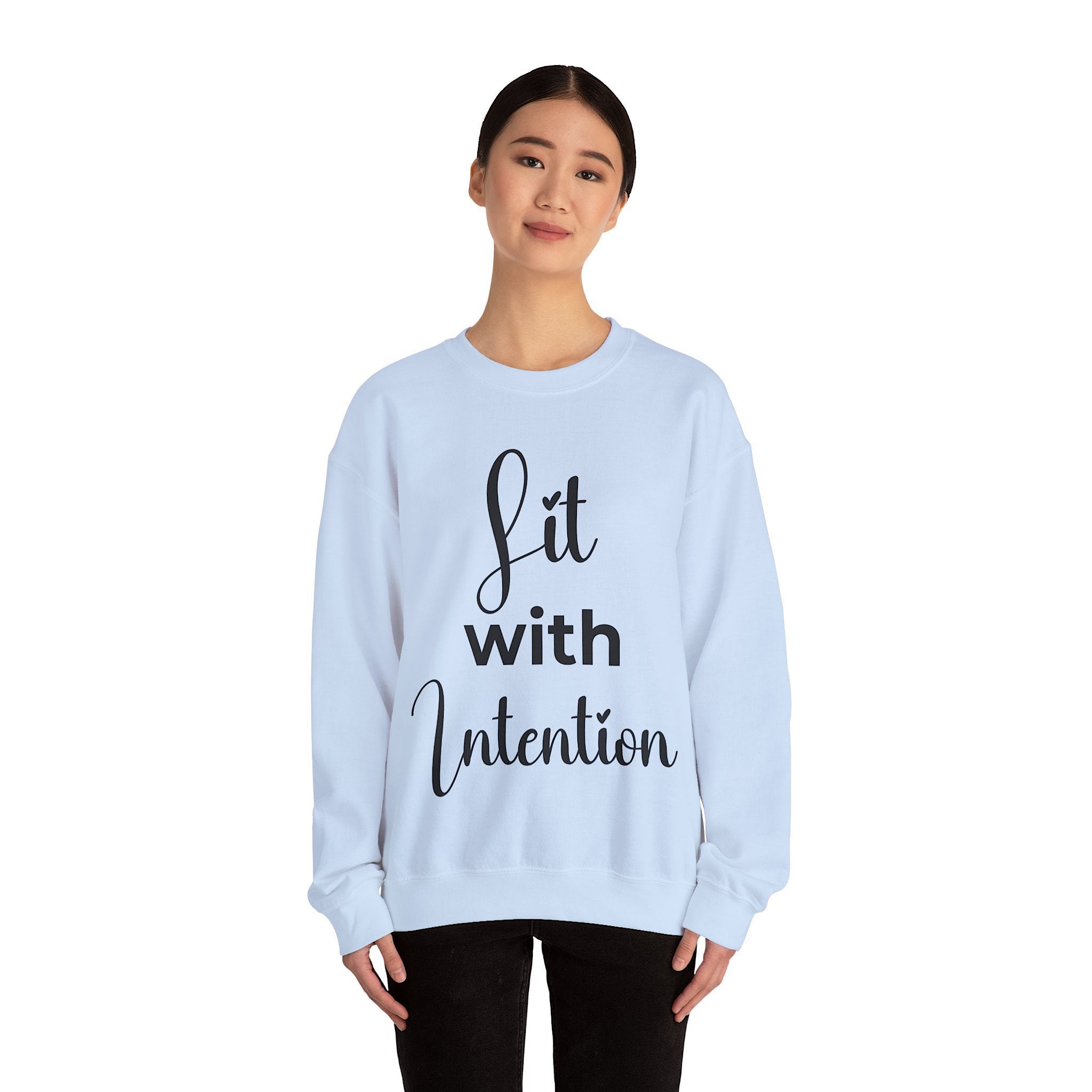 Light blue sweatshirt with 'Lit with Intention' text worn by a person on a white background