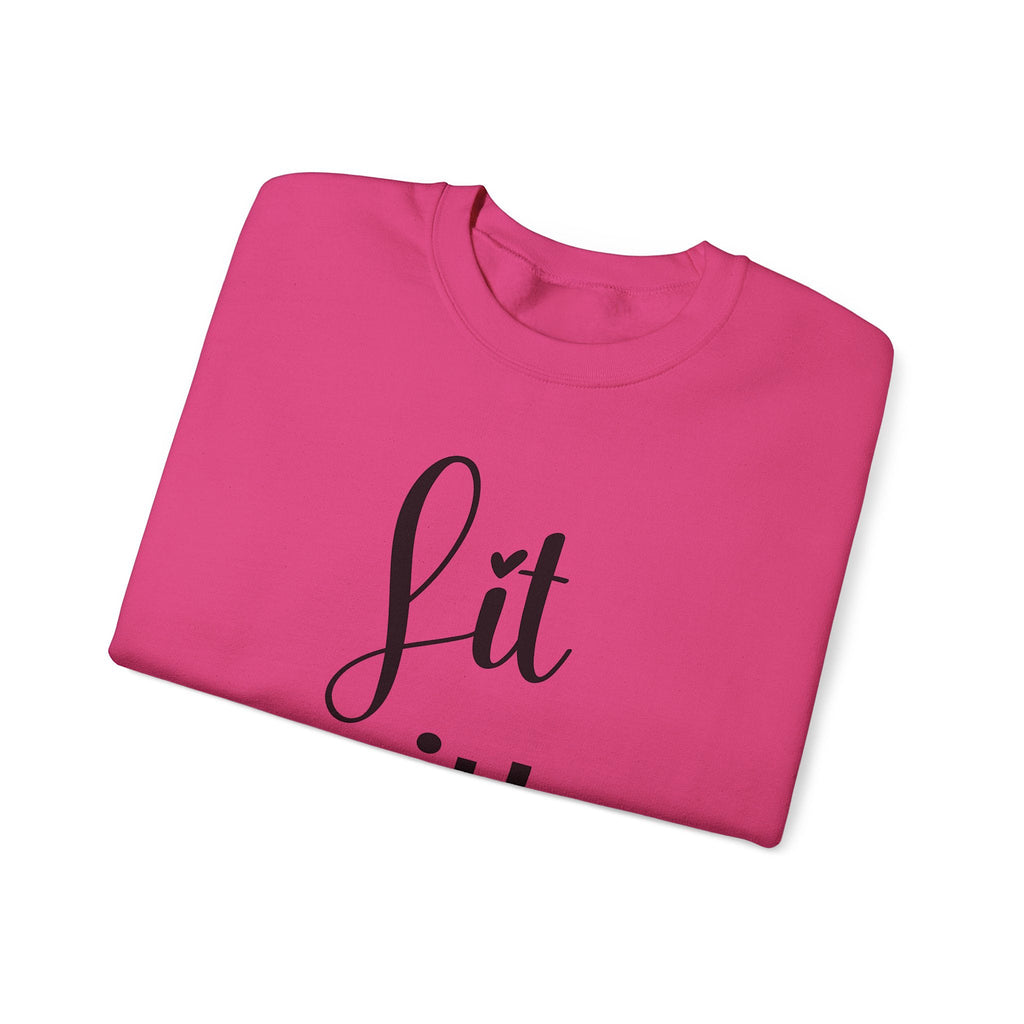 Folded pink sweatshirt with 'Lit with Intention' text on a white background