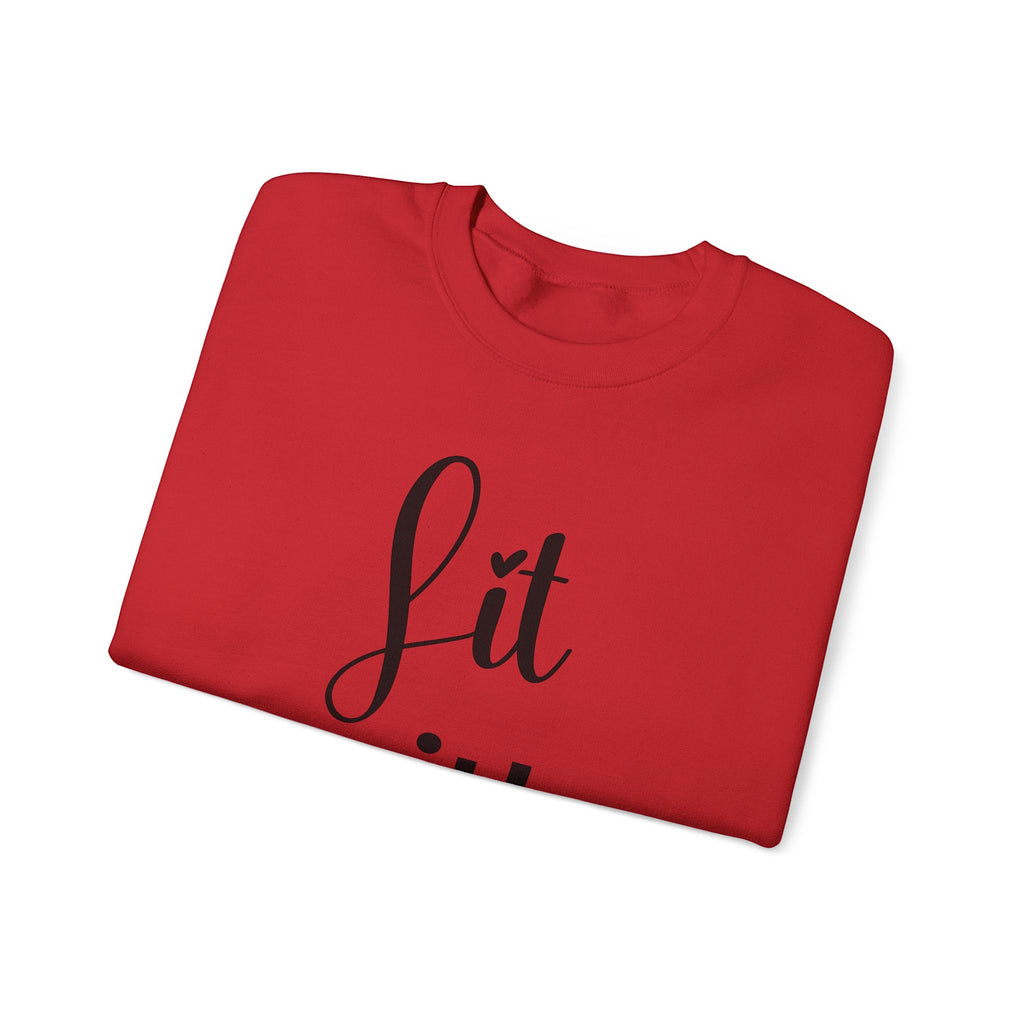 Folded red sweatshirt with 'Lit with Intention' printed on it against a white background