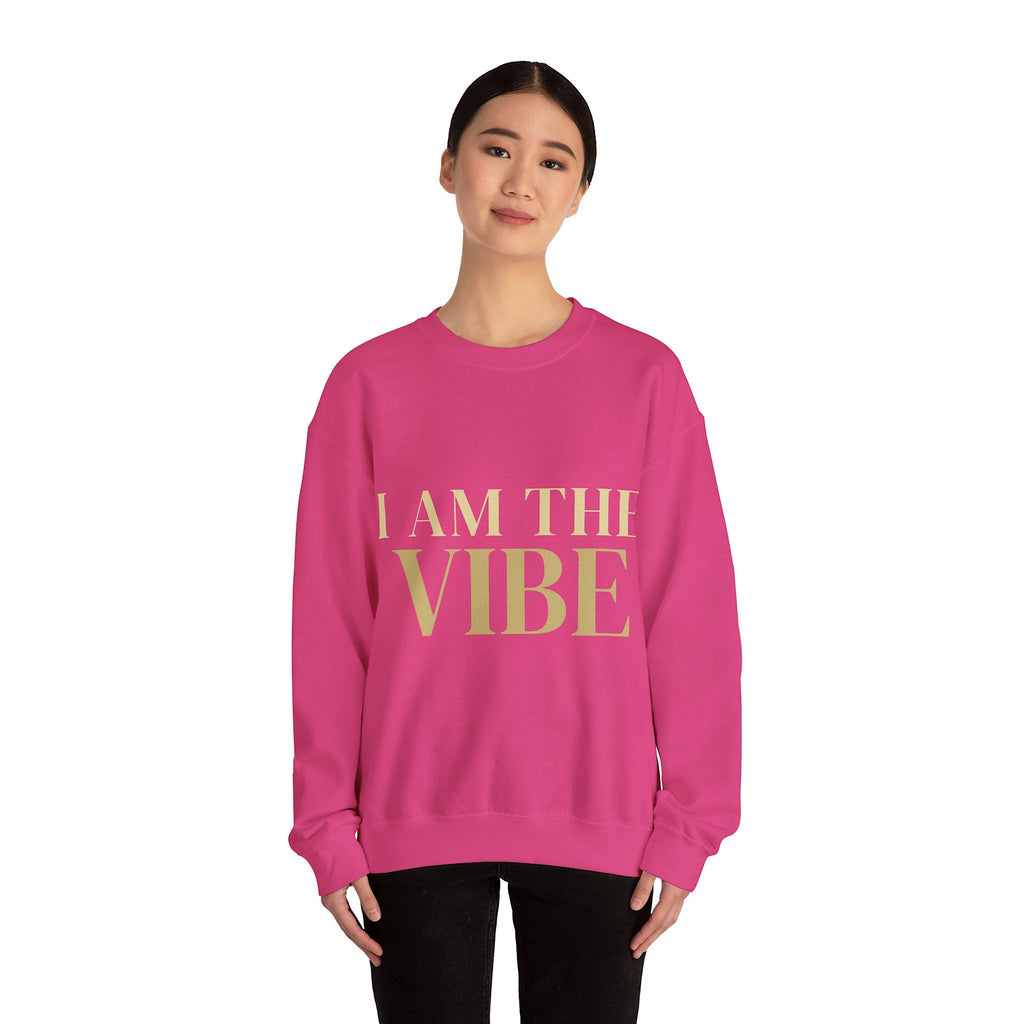 Person wearing a pink sweatshirt with 'I AM THE VIBE' text on a white background