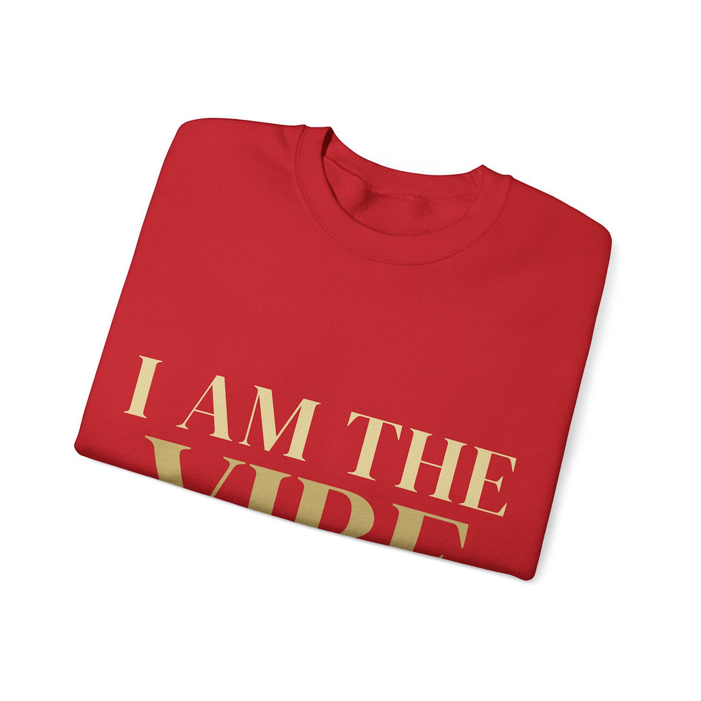 Folded red shirt with 'I AM THE VIBE' text in gold on a white background