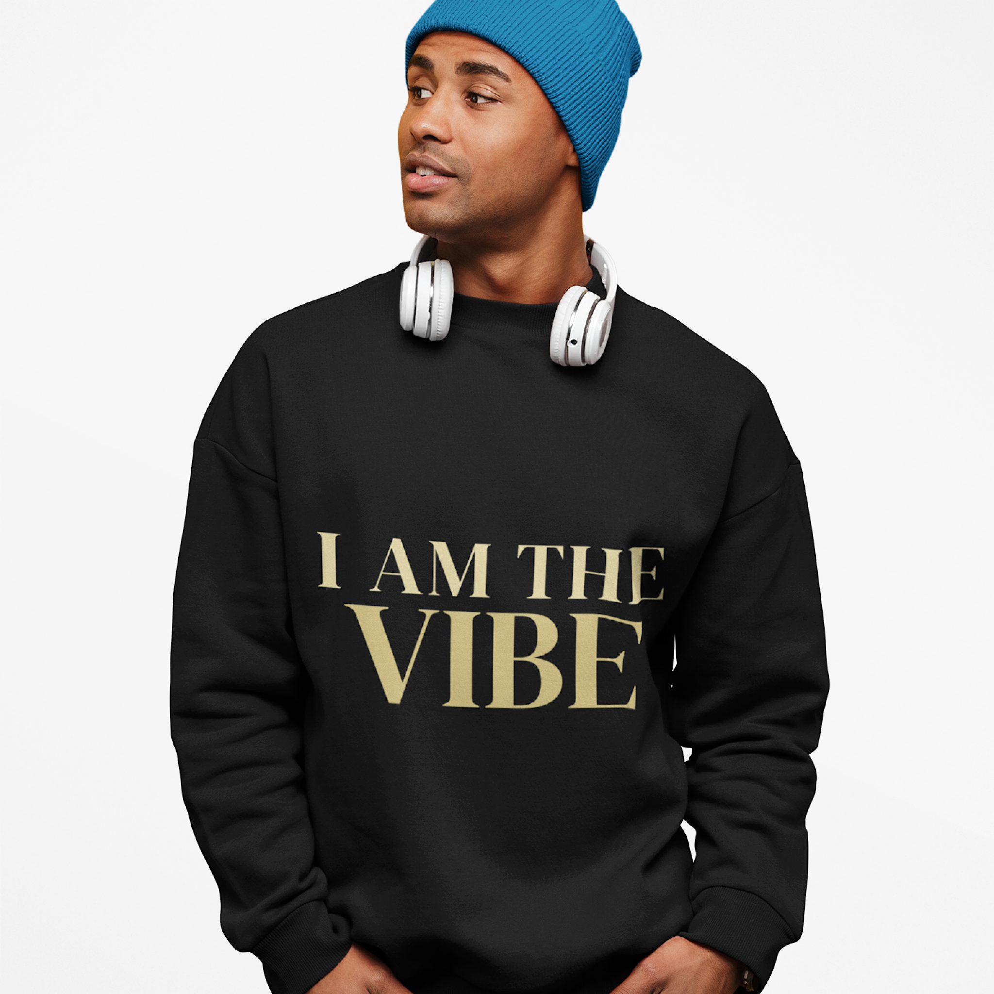 Person wearing a black sweatshirt with 'I AM THE VIBE' text, blue beanie, and white headphones on a light gray background