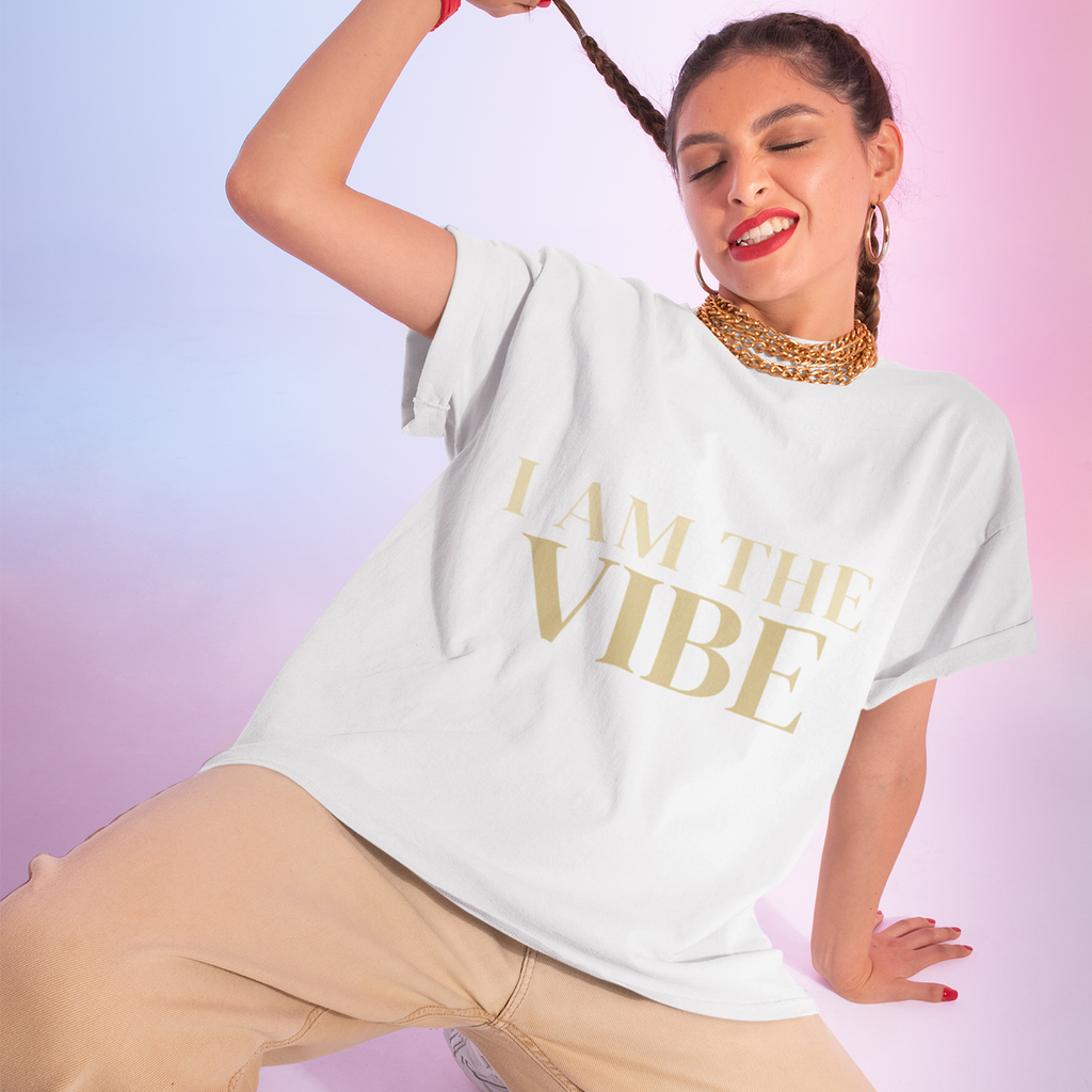 Woman wearing a white t-shirt with 'I AM THE VIBE' text on a gradient background
