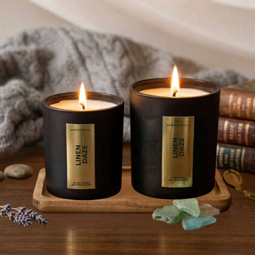 Two lit candles from 'Mom's Bakery' on a wooden tray with books and decorative stones in the background.