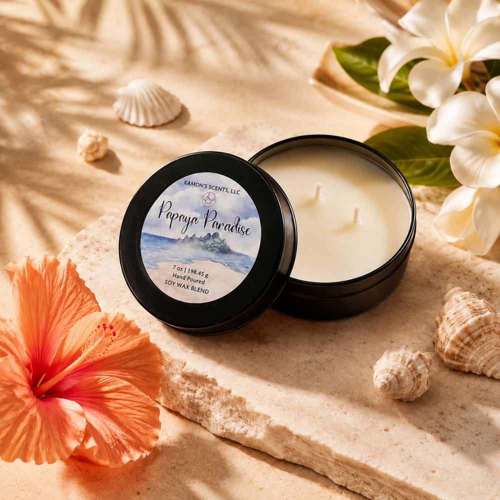 Candle with 'Papaya Paradise' label on sand with flowers and shells