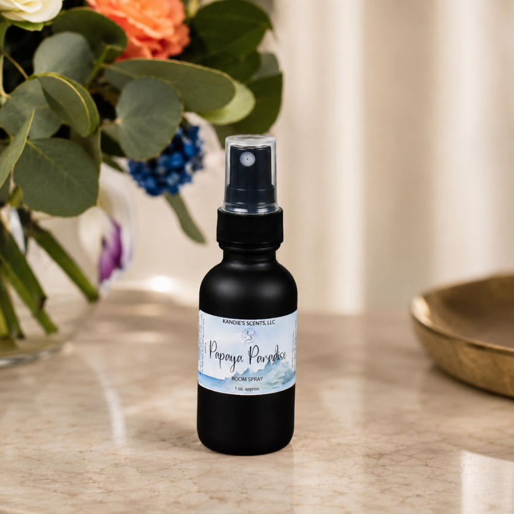 Black room spray bottle with a label on a marble surface with flowers in the background