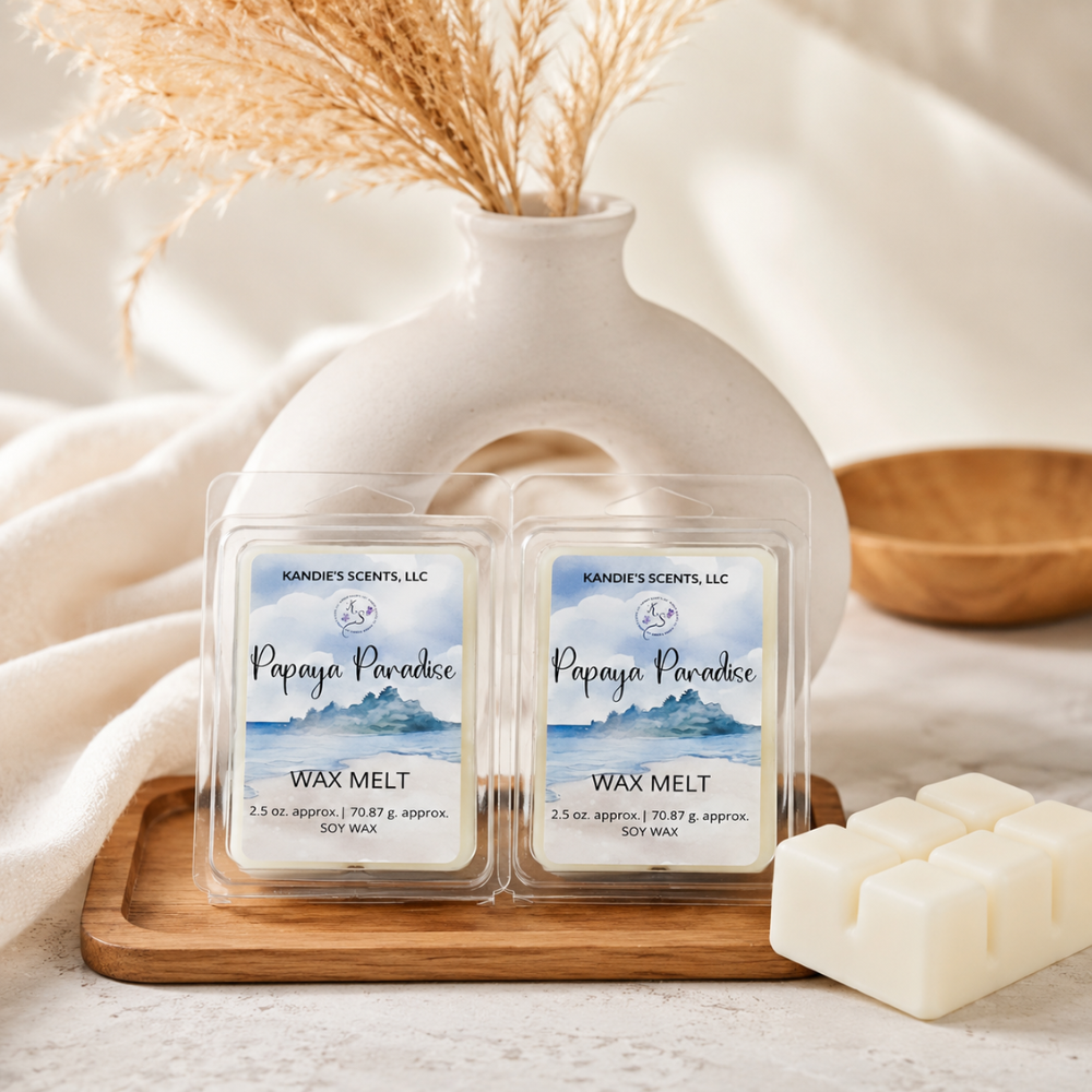 Two 'Papaya Paradise' wax melts on a wooden tray with a vase and wooden bowl in the background.