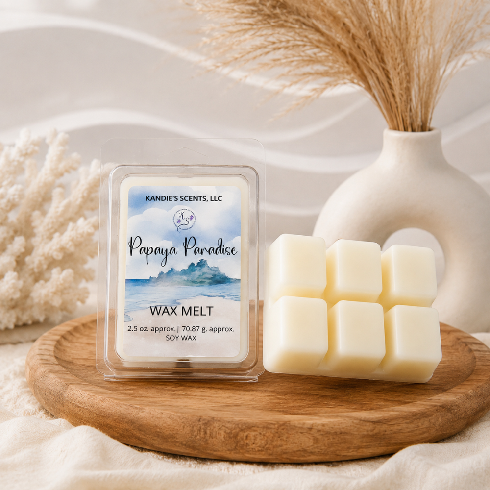 Wax melt packaging labeled 'Papaya Paradise' by Kandie's Scents on a wooden tray with decorative elements.