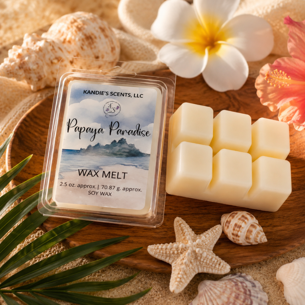 Kandie's Scents Papaya Paradise wax melt packaging with wax cubes on a wooden surface with shells and flowers.