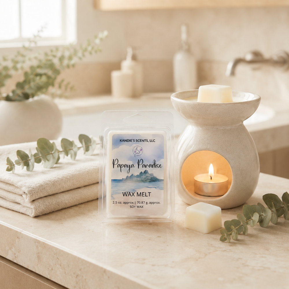 Wax melt packaging with a lit wax melt burner on a bathroom counter.