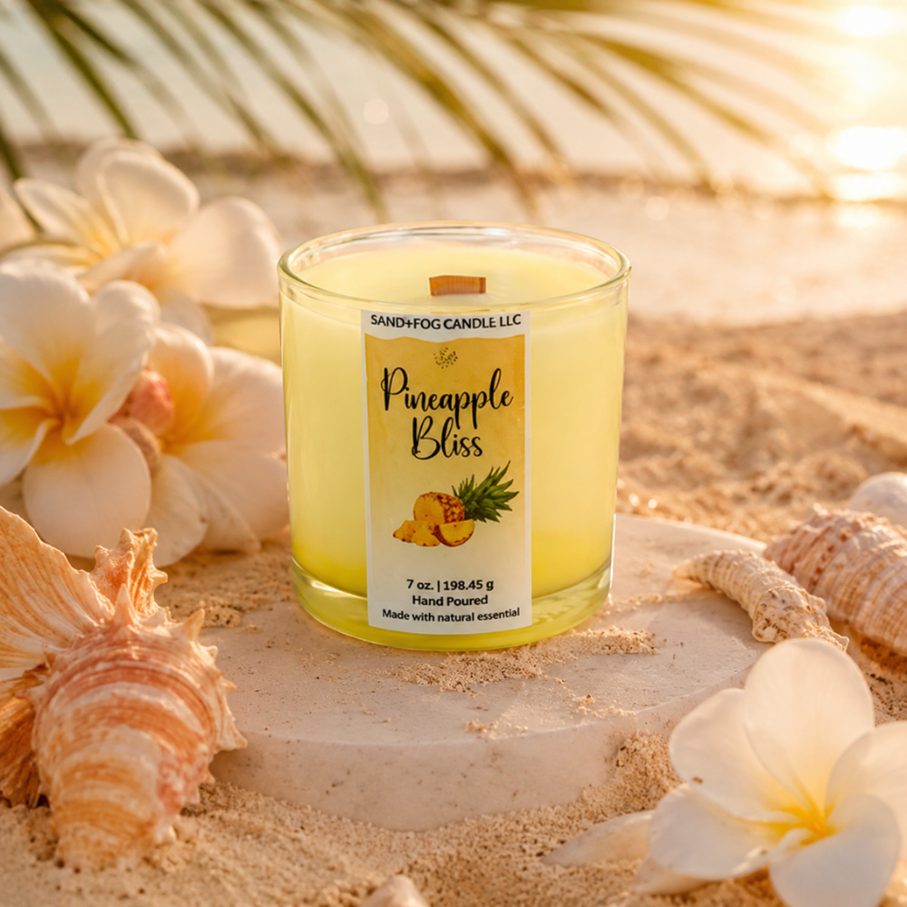 Pineapple Bliss candle on sand with flowers and shells