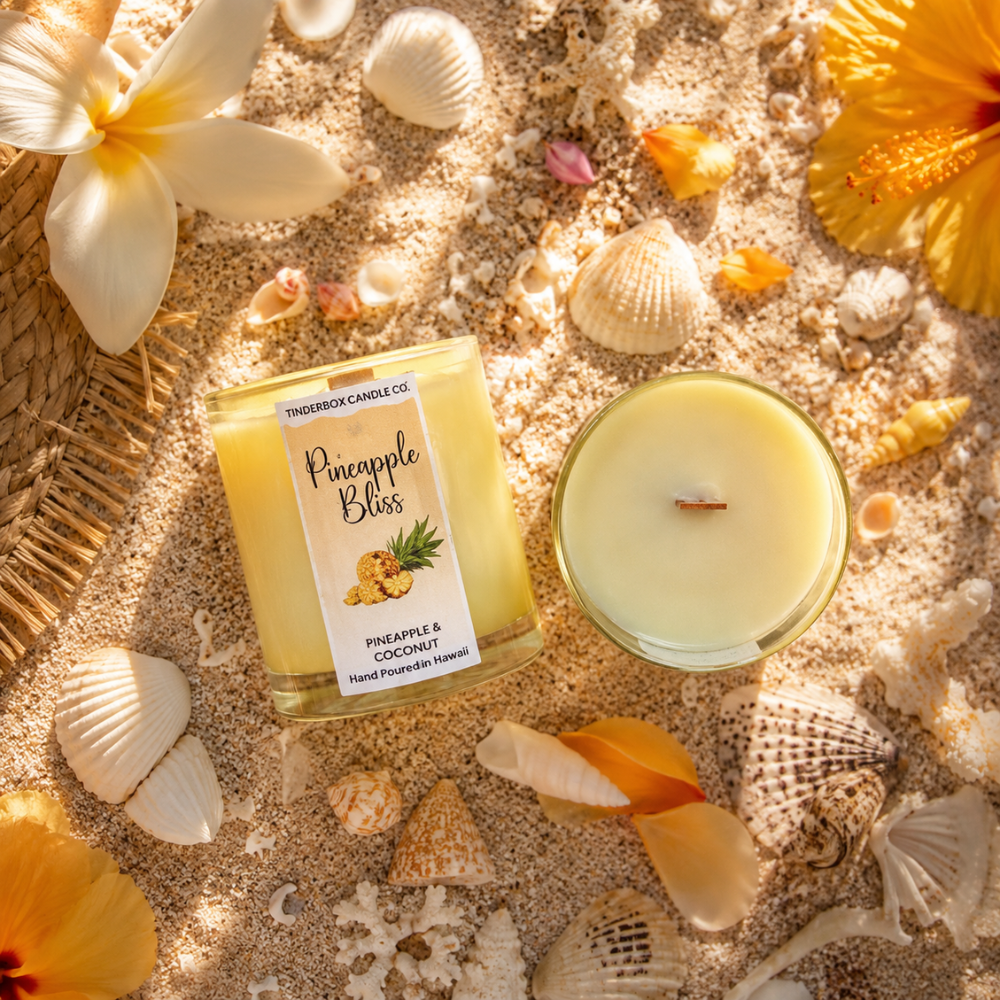 Pineapple Bliss candle on sand with flowers and shells