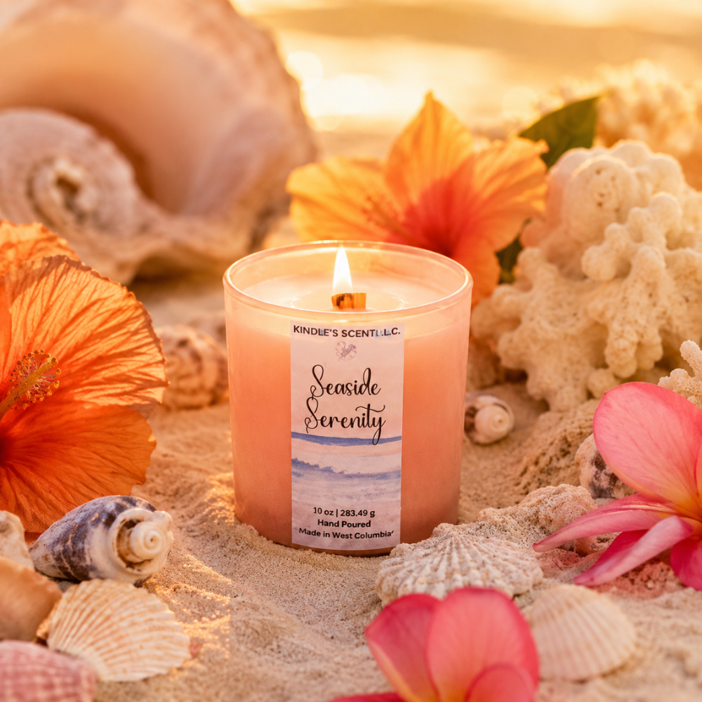 Candle labeled 'Seaside Serenity' surrounded by seashells and flowers on sand