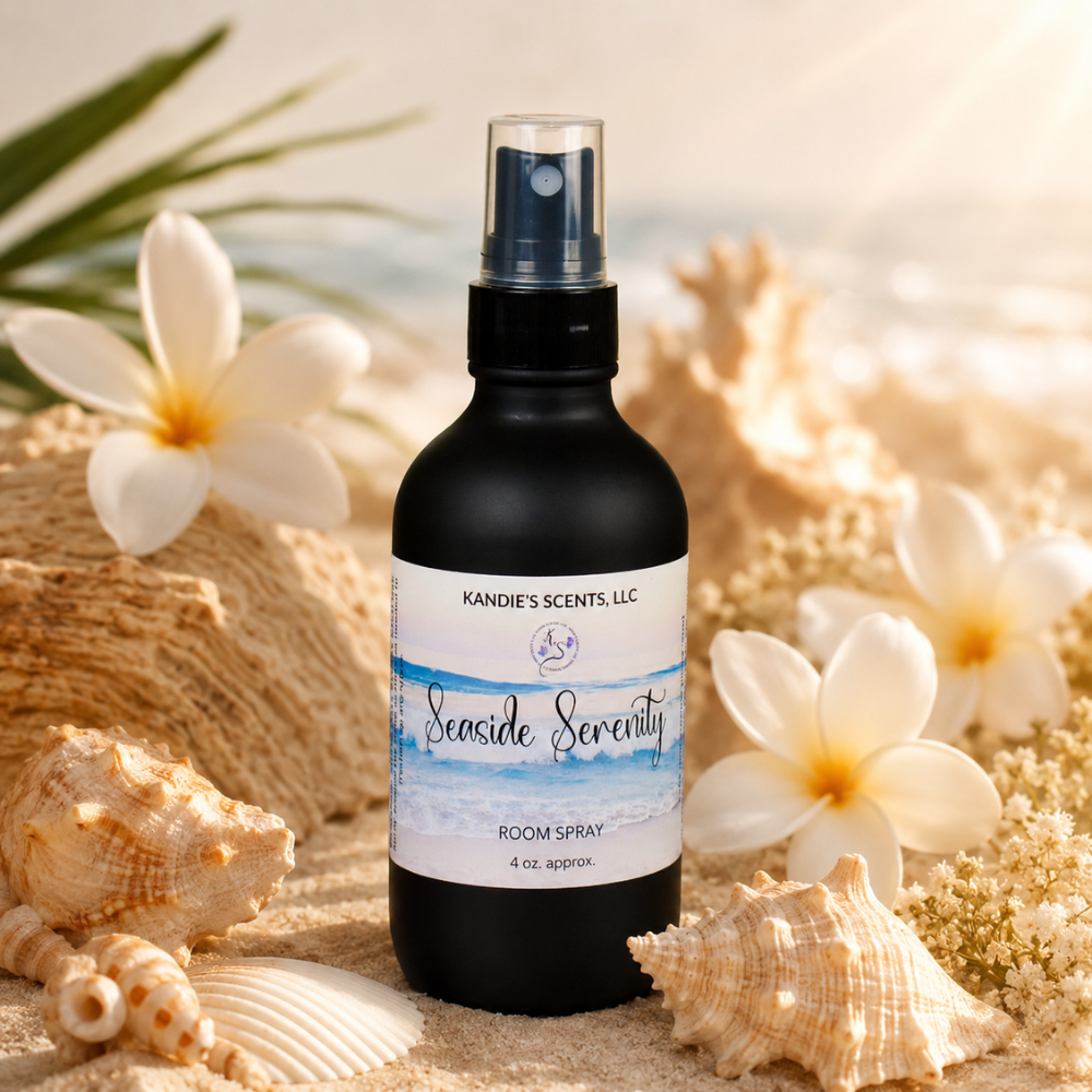 Room spray bottle labeled 'Seaside Serenity' surrounded by flowers and shells on a sandy background