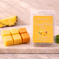 Kandie's Scents Tropical Nectar Glow wax melts on a marble surface with a pineapple in the background.